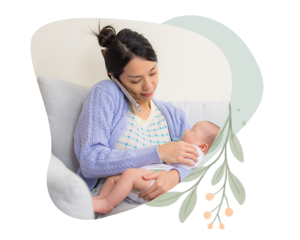 A parent cradles and feeds an infant while talking on the phone, illustrating a caregiver seeking guidance or support from a trusted resource. The image is framed within an organic, rounded shape with a soft sage green background accent.